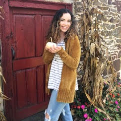 A woman standing in front of a wooden door.