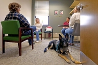 Several students in a therapy group accompanied by a service dog