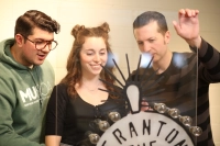 three people looking at light sign through glass panel