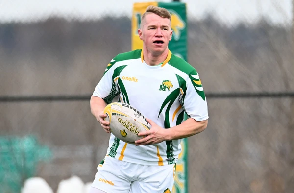A Marywood rugby player running with a ball.