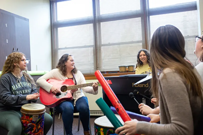 people sitting in circle playing musical instruments