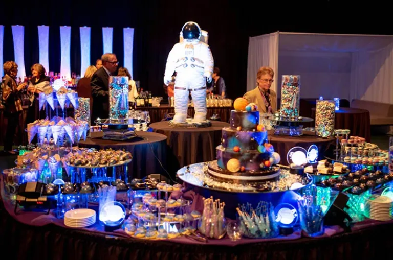 An astronaut figurine is surrounded by galaxy-themed desserts with special lighting to complete the atmosphere of the winning theme.