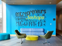 blue mural that says entrepreneurs of all kinds reshape our world