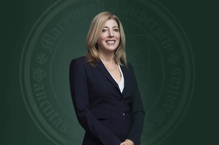 Marywood's 13th President Lisa A. Lori is pictured in a dark blue suit against a green backdrop with the Marywood seal.