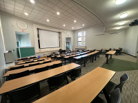 A man presenting to students sitting in rows of seats in the Comerford auditorium