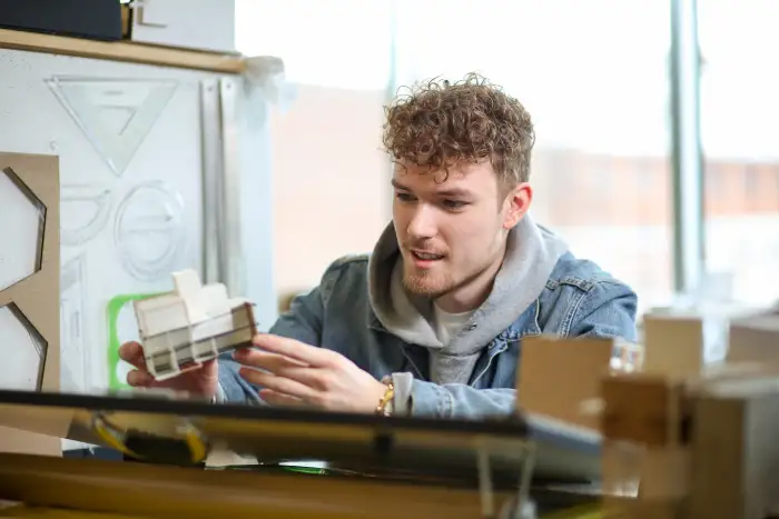 An architecture student working on a model