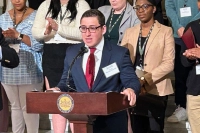 Other college students surround Marywood student Scott Gartley, who is standing at a podium on the steps of the Pennsylvania State Capitol in Harrisburg, Pa., advocating for educational causes.